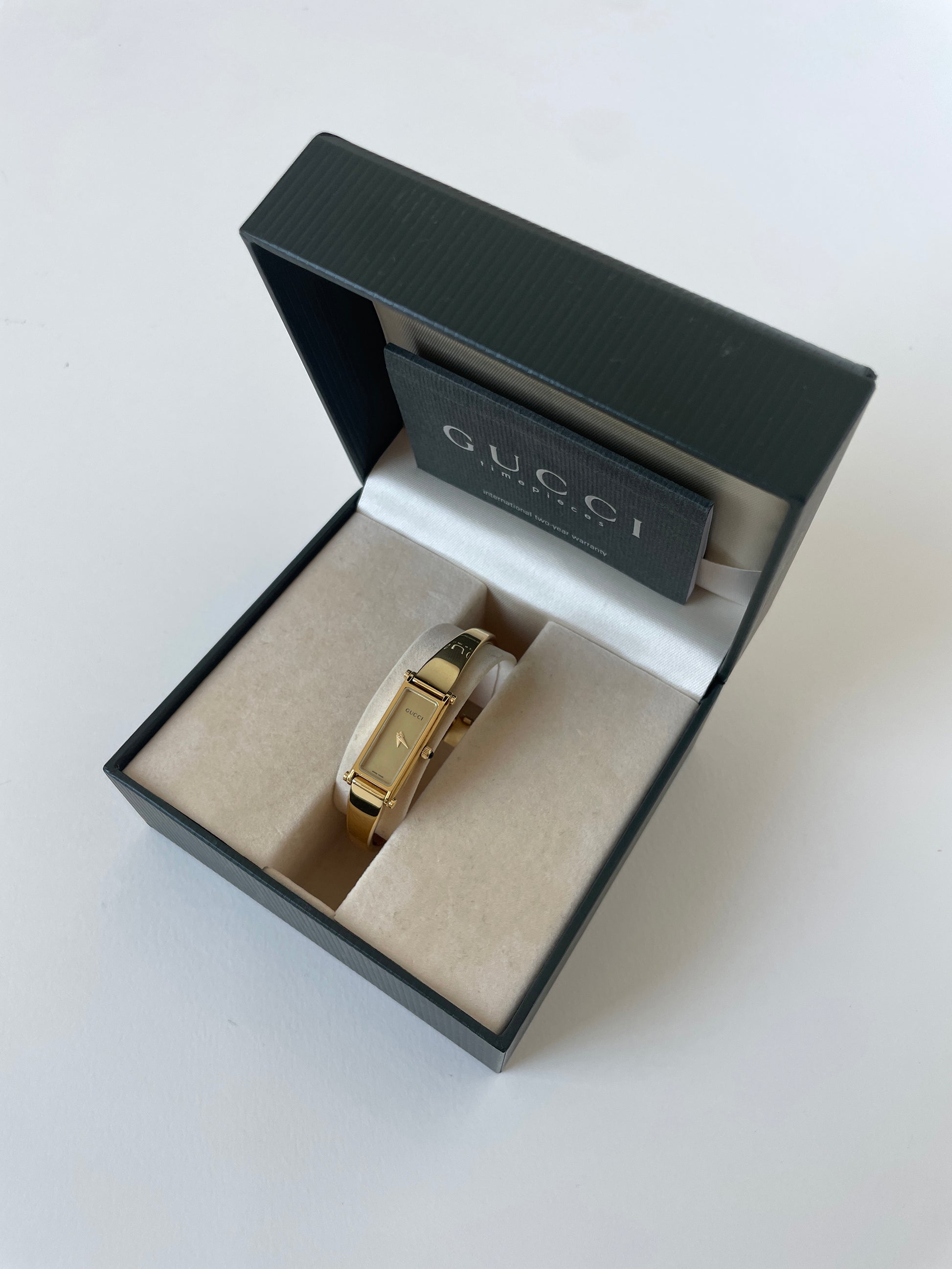 Vintage Gucci by Tom Ford 2000s 1500L 18K gold plated bangle watch with light golden dial and horsebit clasp.