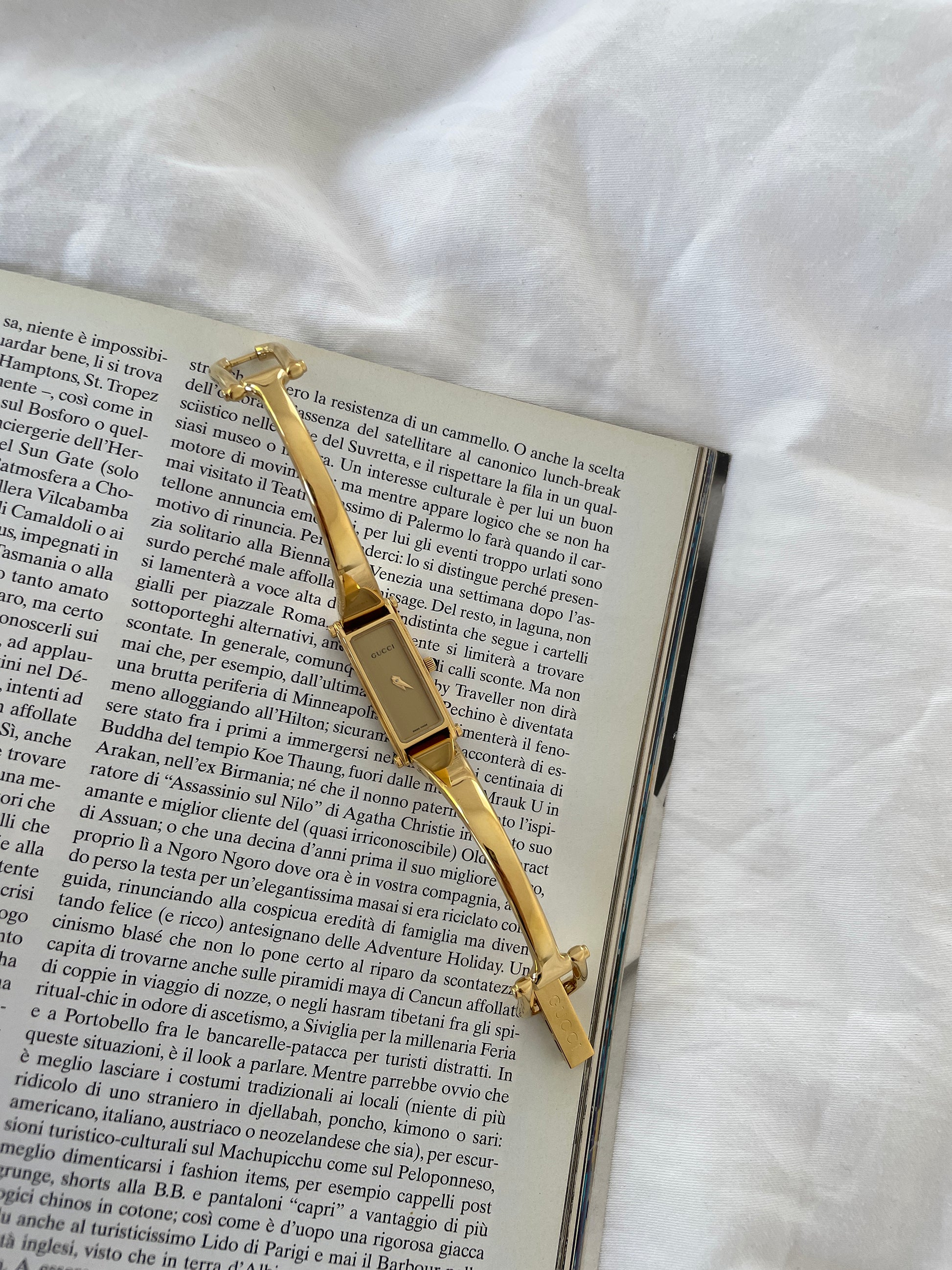 Vintage Gucci by Tom Ford 2000s 1500L 18K gold plated bangle watch with light golden dial and horsebit clasp.