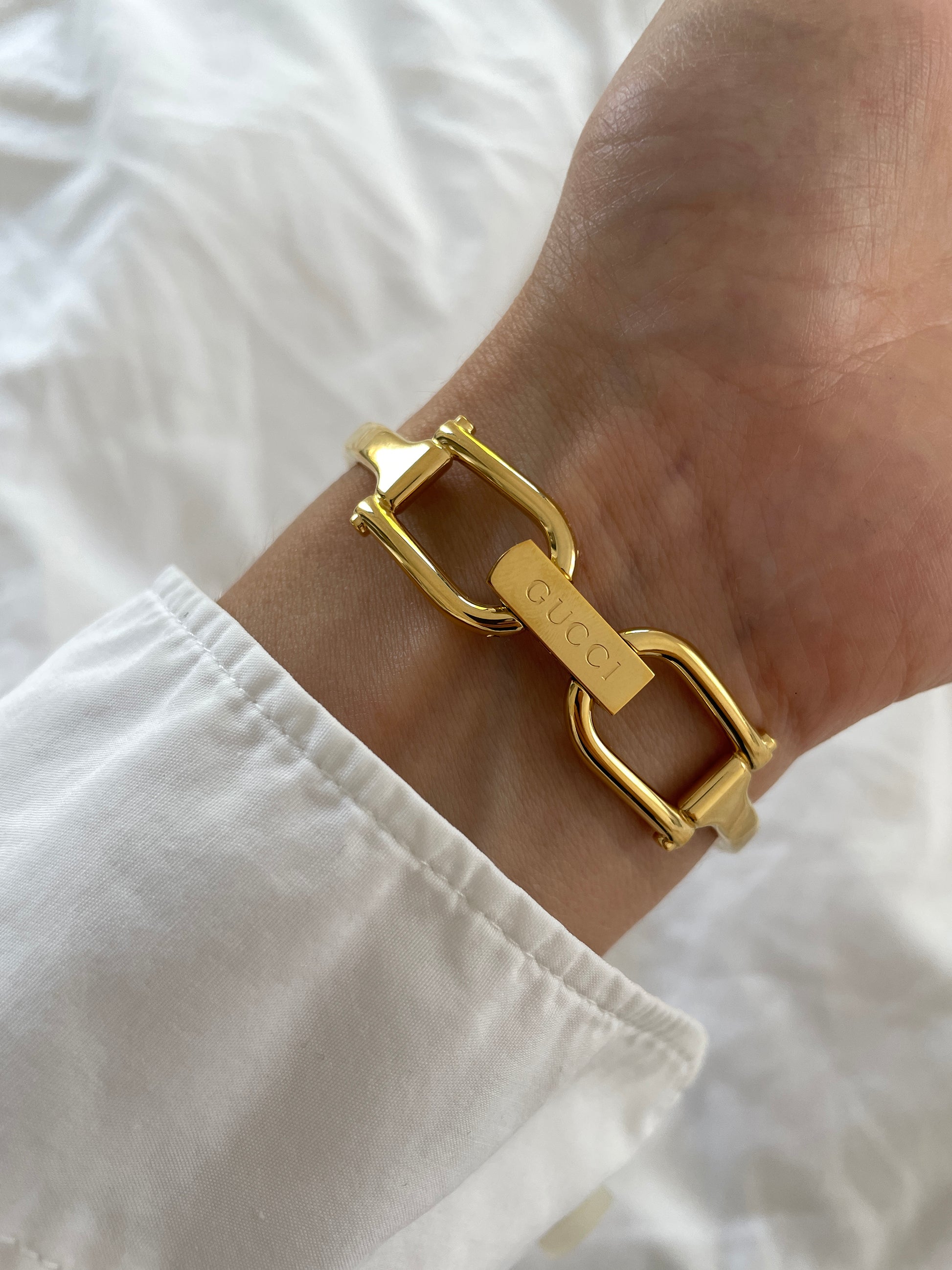 Vintage Gucci by Tom Ford 2000s 1500L 18K gold plated bangle watch with light golden dial and horsebit clasp.