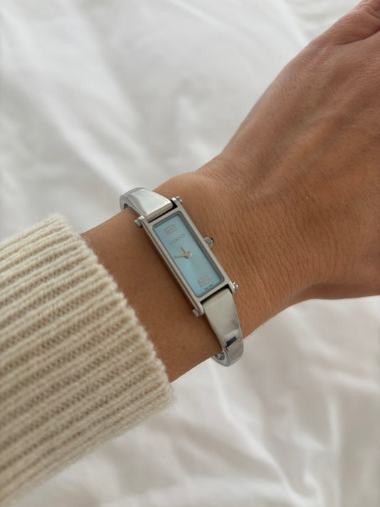 Vintage Gucci by Tom Ford 2000s 1500L silver bangle watch with baby blue dial and horsebit clasp.