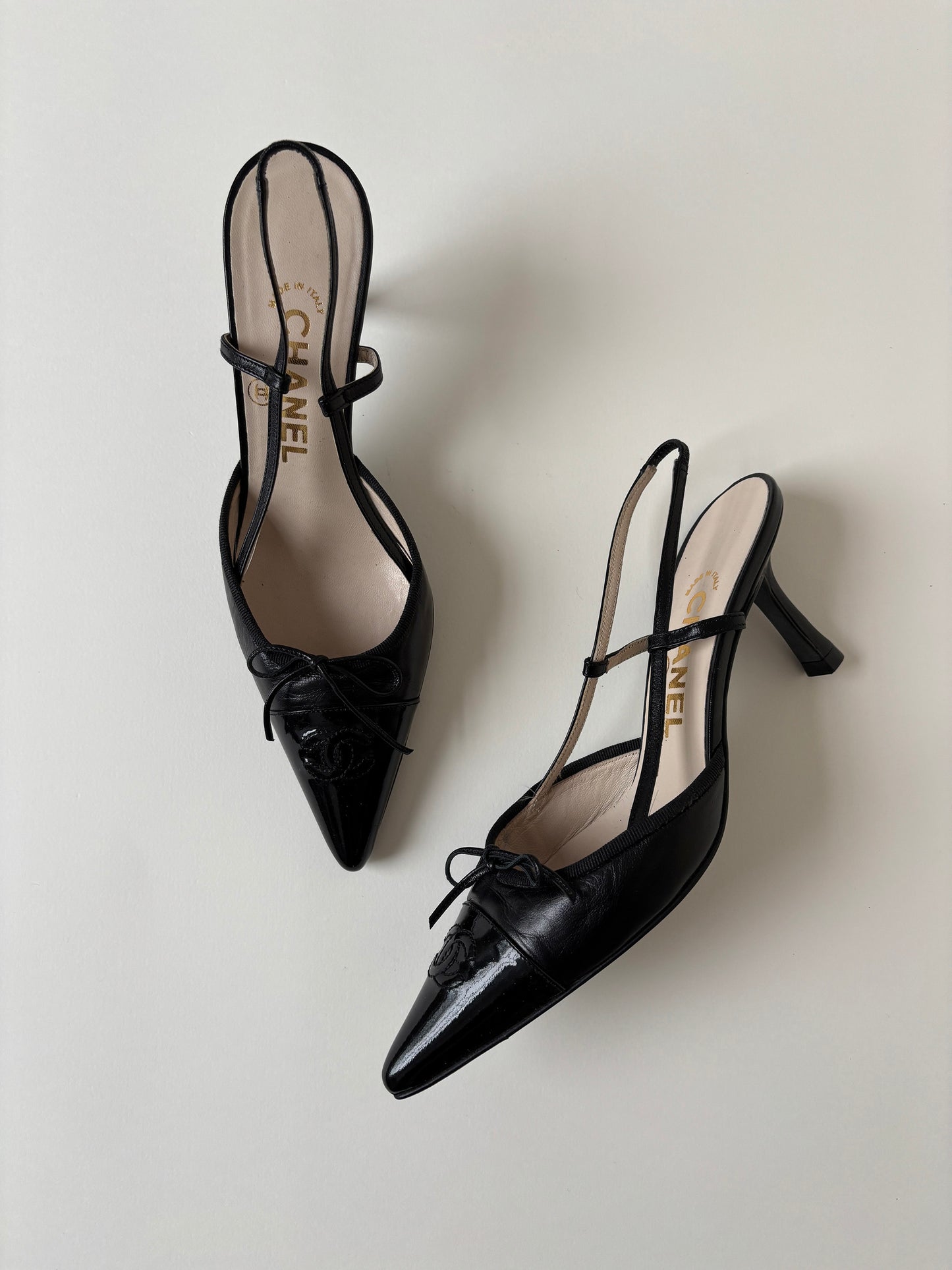 Vintage iconic Chanel 2000s pointed black CC sling back kitten heels with cute bow detail.