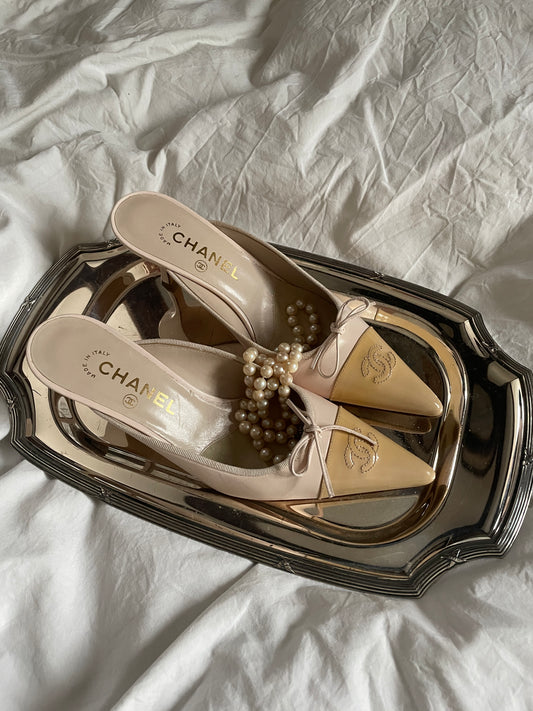 Vintage Chanel bow mules on a silver plate