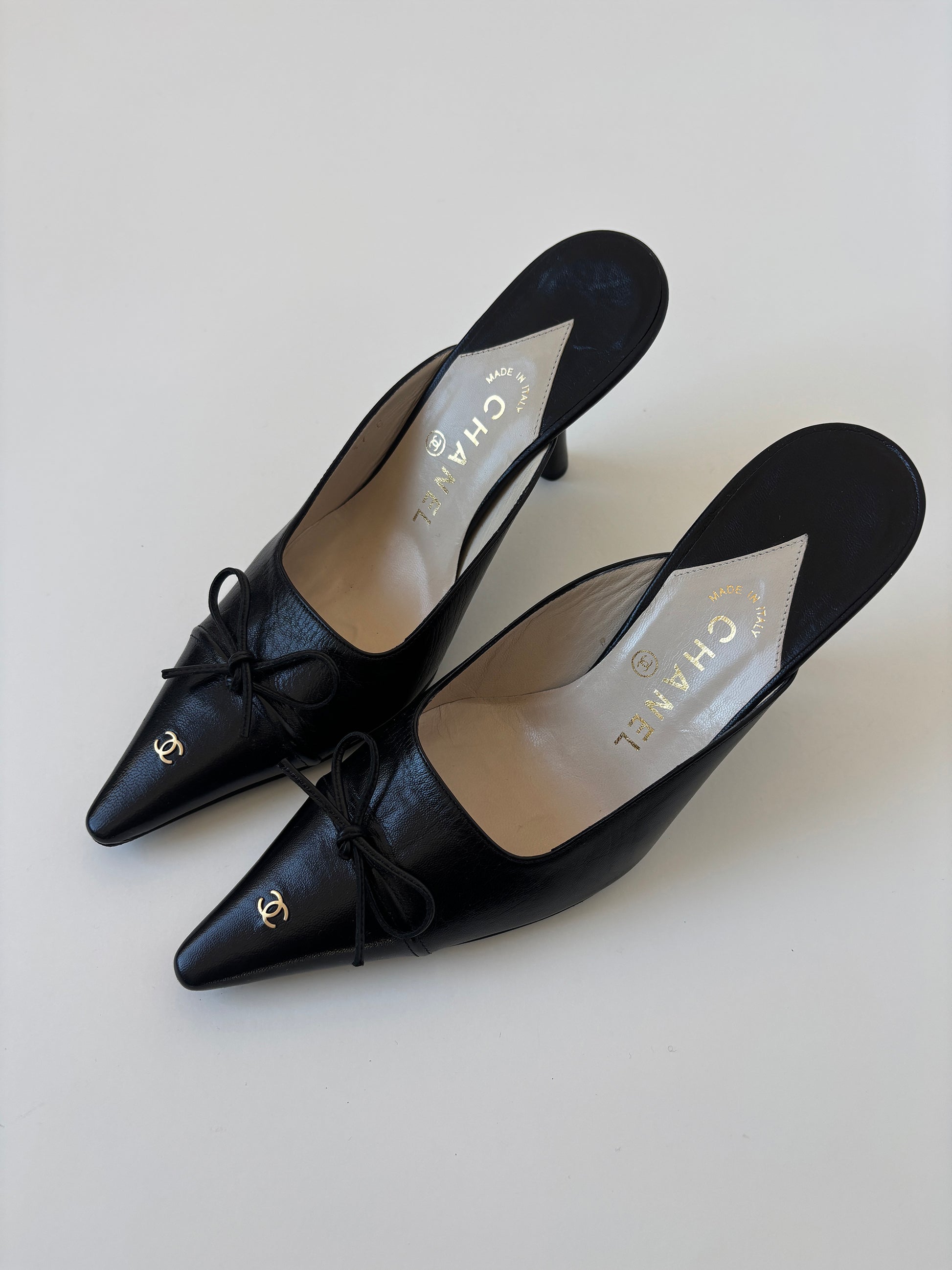 Vintage iconic Chanel 2000s pointed black CC kitten mules with tiny CC golden logo at the top and the heels.