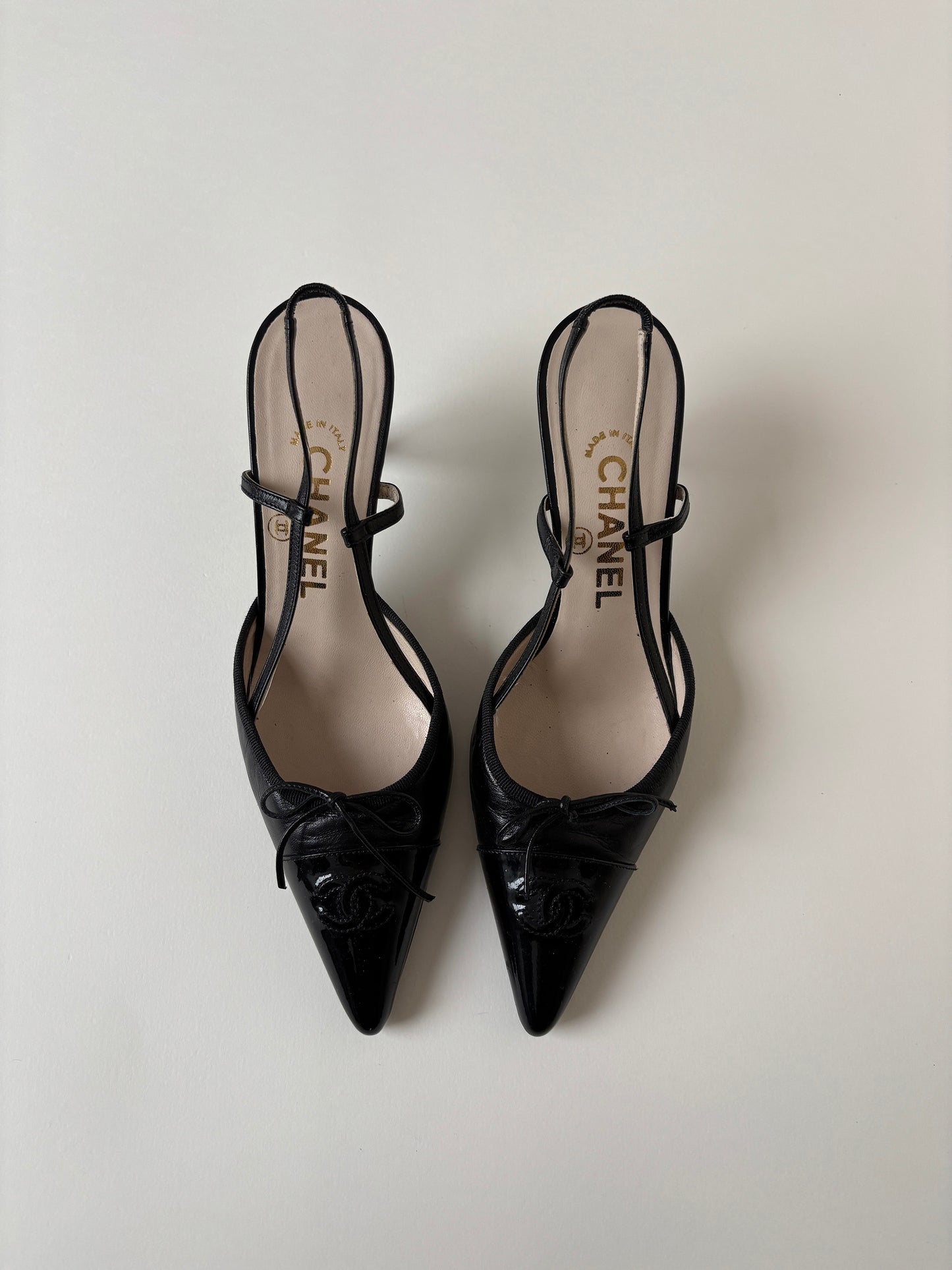 Vintage iconic Chanel 2000s pointed black CC sling back kitten heels with cute bow detail.