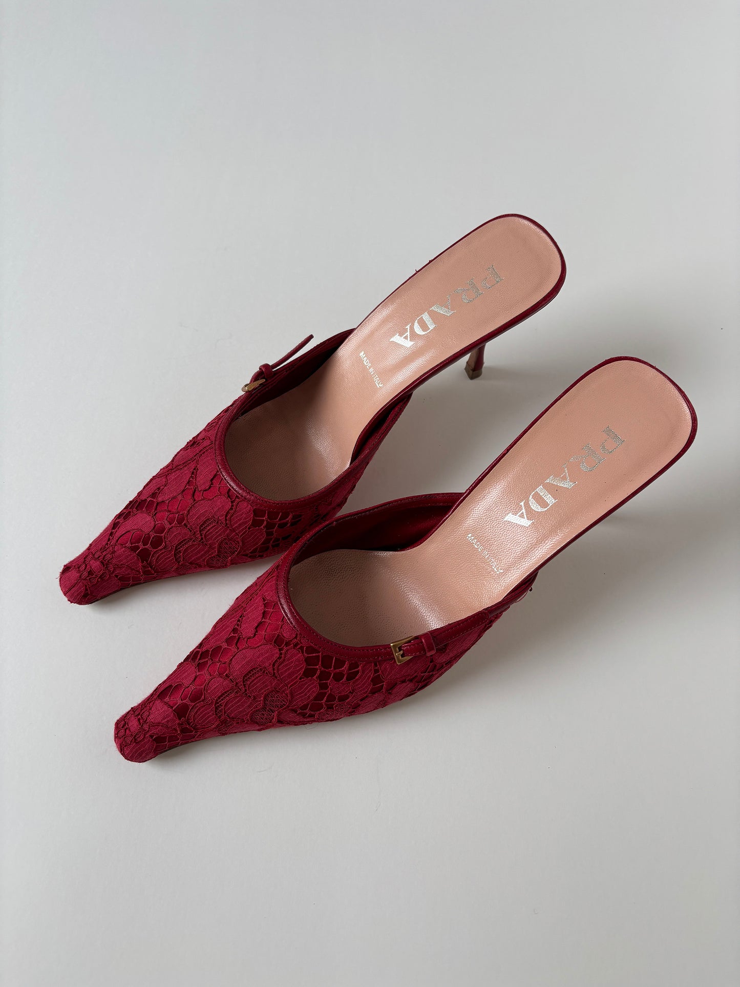 Vintage Prada 2000s red lace kitten heel mules with silver buckle details.&nbsp;