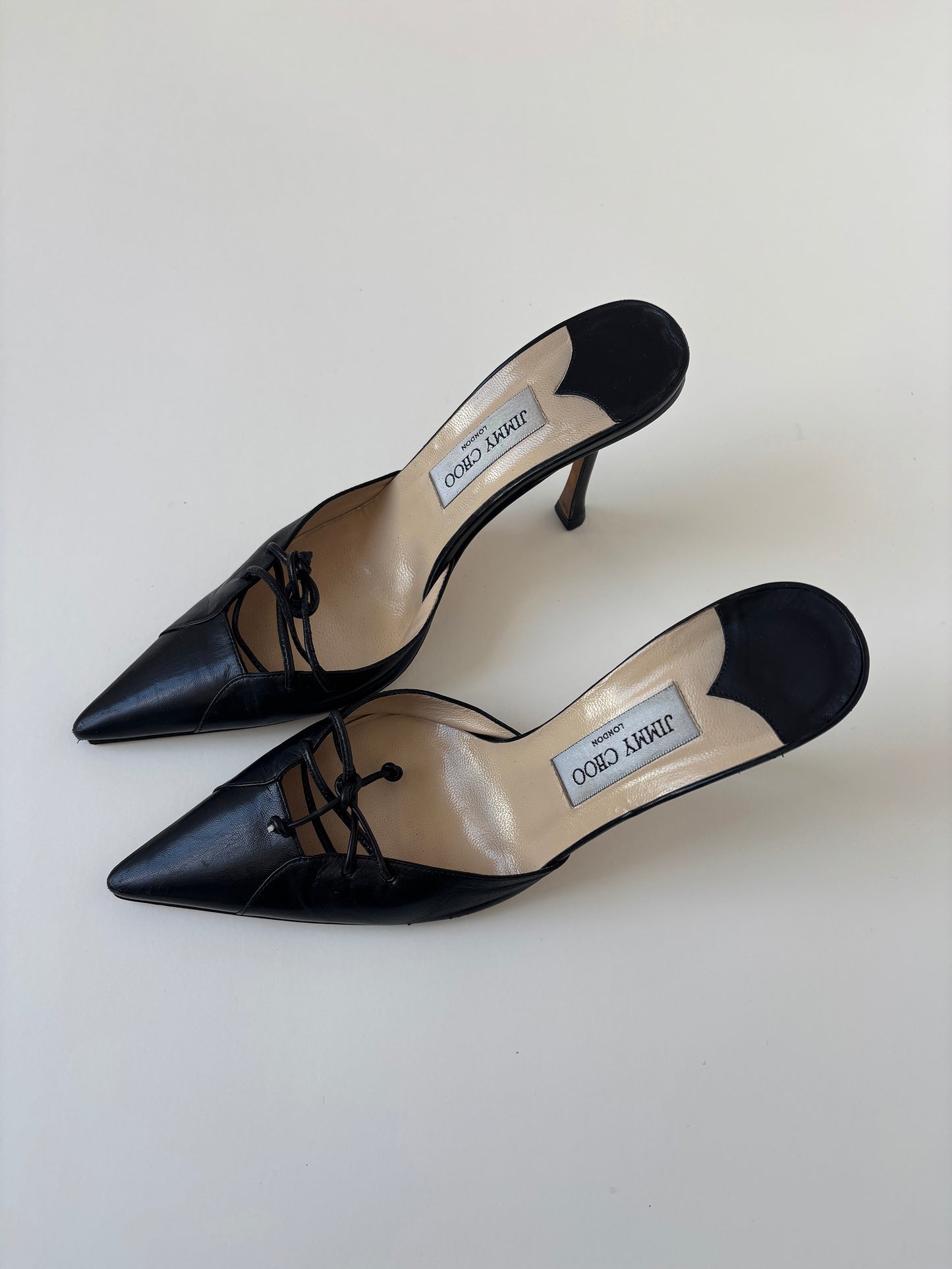 Vintage Jimmy Choo 2000s black mules with lace bow details.