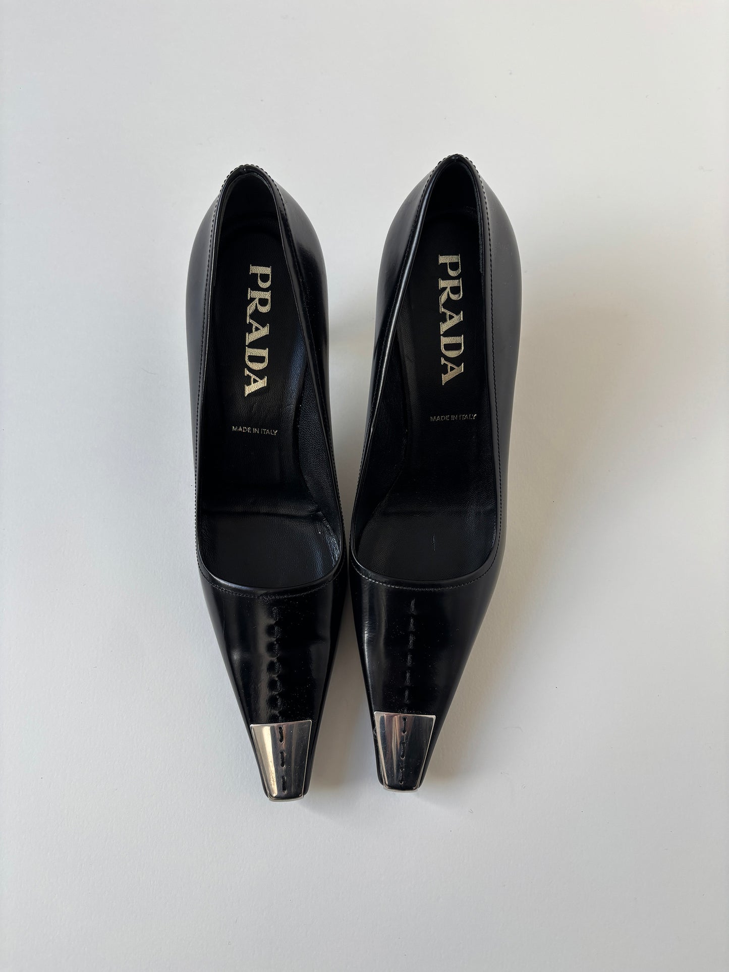 Vintage Prada 2000s black kitten heels with silver metal cap details.